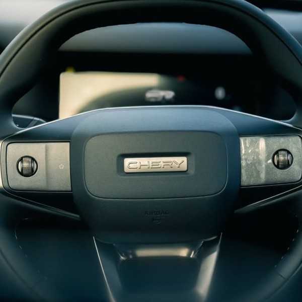 Detail Interior Chery J6 T, setir multi-fungsi palang empat dengan logo Chery di bagian klakson dan berbagai tombol kontrol di jari-jari.